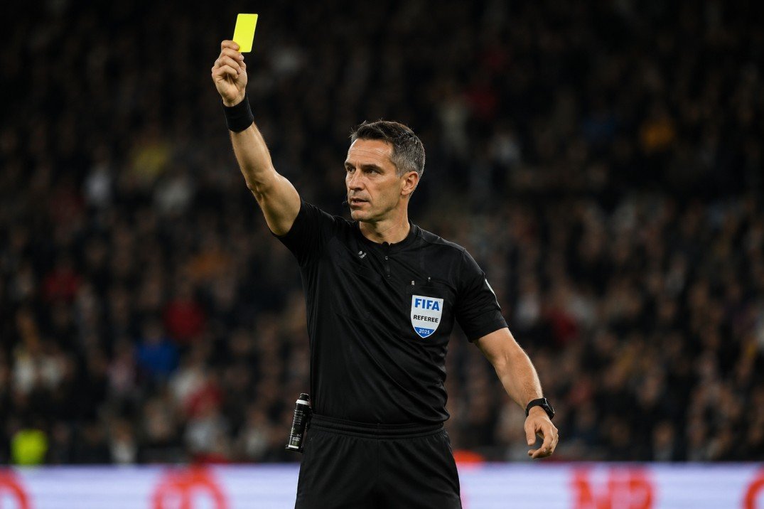Champions League yellow card suspension rules explained with football players receiving bookings during a UEFA match.
